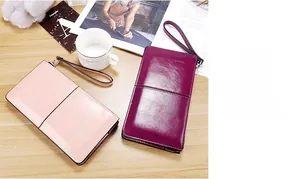 Detailed view of glossy oil wax leather long wallets in pink and burgundy colors