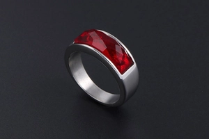 Detailed macro view of silver stainless steel ring with rectangular red faceted stone