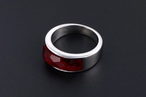 Top view of a silver stainless steel ring with a rectangular faceted red gemstone
