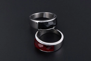Detail of silver stainless steel rings with faceted black and deep red gemstones
