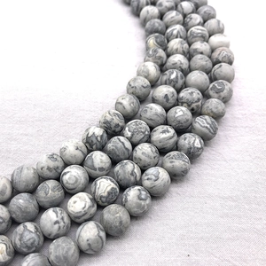 Matte natural map stone round beads for DIY jewelry making displayed on light fabric