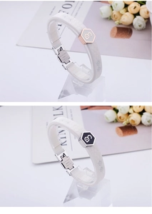 Detailed close-up of white silicone energy bracelet with hexagonal honeycomb metal charms
