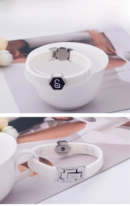 Detail of white silicone sports band with hexagonal steel plate and engraved logo