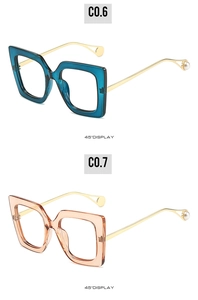 Nahaufnahme eckiger blauer und champagnerfarbener Brillen mit eleganten Perlendetails