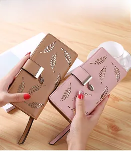 Detail of laser-cut leaf pattern on women's long wallet with metallic pendant