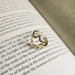 Vista macro di un anello a stella dorato minimalista su una pagina di libro aperto