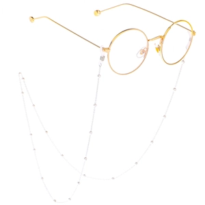 Detailed view of gold round glasses with silver beaded anti-slip chain on white background