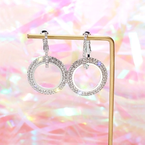Macro detail of silver geometric hoop earrings with shimmering cubic zirconia settings