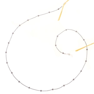 Detailed close-up of dark grey beaded eyewear chain with silicone loops on gold glasses