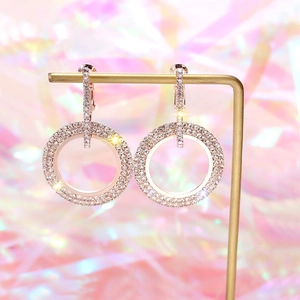 Macro shot of rose gold double hoop earrings with pave-set zircon on a display stand