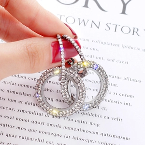 Macro detail of silver hoop earrings featuring full pavé sparkling rhinestones