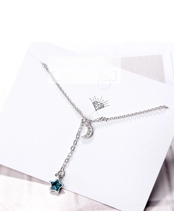 Detail of silver moon and blue star necklace featuring sparkling zircon crystals