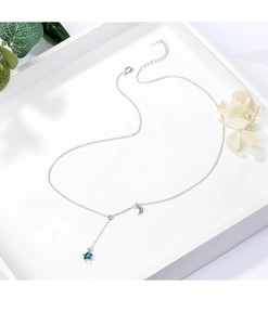 Close-up of blue star and moon necklace on a white tray with elegant floral accents