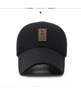 Detail of black cotton baseball cap featuring a premium brown leather logo patch on front