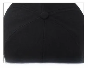 Detailed top view of a black cotton baseball cap showing six-panel stitching and top button