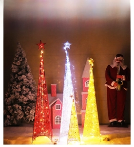 Gros plan sur des sapins de Noël en métal éclairés avec cimes étoilées et lumières LED