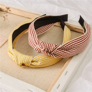 Detail of striped knotted headbands in yellow and red with soft woven fabric texture