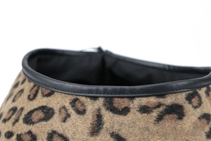 Detail of leopard print wool beret featuring black leather trim and neat stitching
