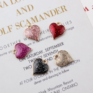 Detailed close-up of glitter enamel heart charms in five colors for DIY jewelry making