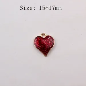 Detail view of heart-shaped glitter pendant in red and gold finish, size 15x17mm