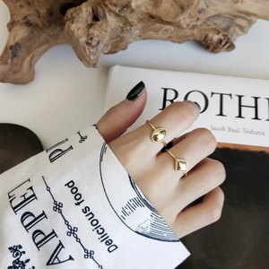 Close-up of geometric gold-plated silver rings with oval and square plates on hands