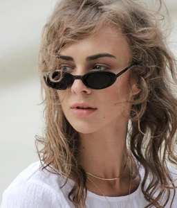 Close-up of black oval frame sunglasses with minimalist design and sleek finish