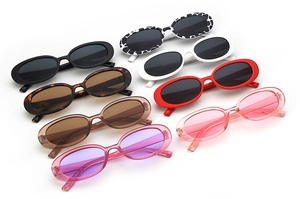 Multiple vintage oval sunglasses shown in cow print, tortoiseshell, and vibrant colors