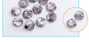 Macro shot of smoky marble hexagonal nail charms with single crystal rhinestone accent