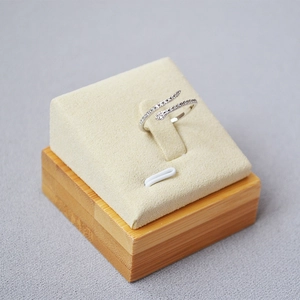 Close-up of a silver-toned snake ring with sparkling diamonds on a beige display stand