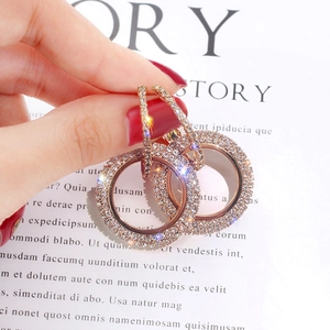 Handheld display of double hoop earrings with pave diamonds in rose gold finish