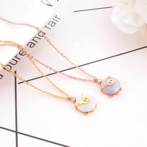 Detailed close-up of pig charms in gold and rose gold with white opal finish for bracelets