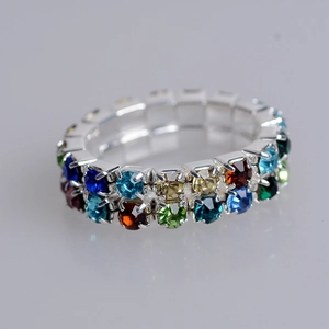 Macro detail of the three-row stretch ring with multicolor crystal rhinestones and silver base