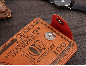 Close-up of vintage brown leather wallet with US dollar pattern and silver magnetic snap