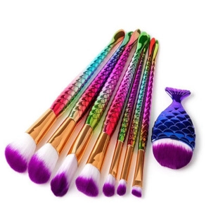 Macro view of mermaid makeup brushes with rainbow fish scale texture and purple bristles