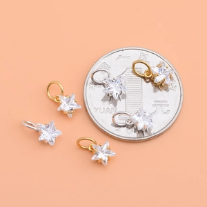 925 silver star pendant with cubic zirconia in gold and silver beside a coin for scale