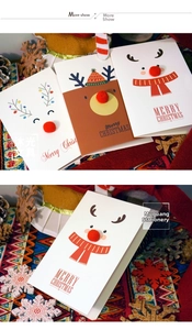 Detail of Christmas cards with 3D red pom-pom reindeer noses and festive patterns