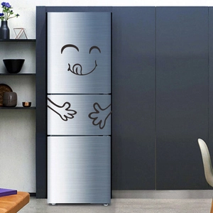 Detailed view of creative black cartoon smiley face magnet on a silver three-door refrigerator