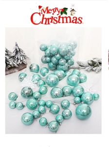Detail of light blue glossy Christmas baubles set with silver caps on white fabric background