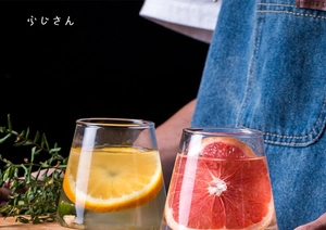 Close-up of Mount Fuji glass cups filled with fresh fruit drinks on a wooden tray