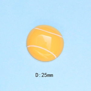 Macro shot of a 25mm yellow resin tennis ball flatback charm with white seam texture