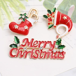 Detail view of festive Christmas brooches with Merry Christmas letters and red stocking