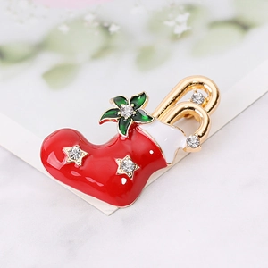 Detailed view of Christmas stocking brooch with red enamel, gold alloy, and sparkling crystals