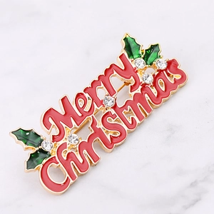 Detailed macro shot of a red enamel Merry Christmas brooch with holly leaves and crystals