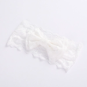 Detailed close-up of a white lace baby headband featuring a delicate bow design