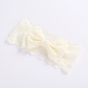 Close-up of beige double-layered lace bow on baby headband with soft texture detail
