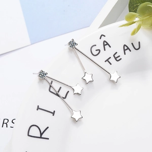 Elegant silver star tassel earrings with white zircon on a white ceramic display plate