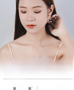 Detailed view of silver star tassel earrings with 4mm white zircon on female model