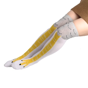 Close-up of funny chicken feet over-knee socks with yellow printed claws on white cotton