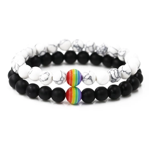 Detail of beaded bracelets with matte black lava and white marble stones in studio lighting