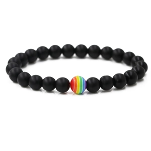 Matte black volcanic stone bracelet with a colorful rainbow stripe bead on white background